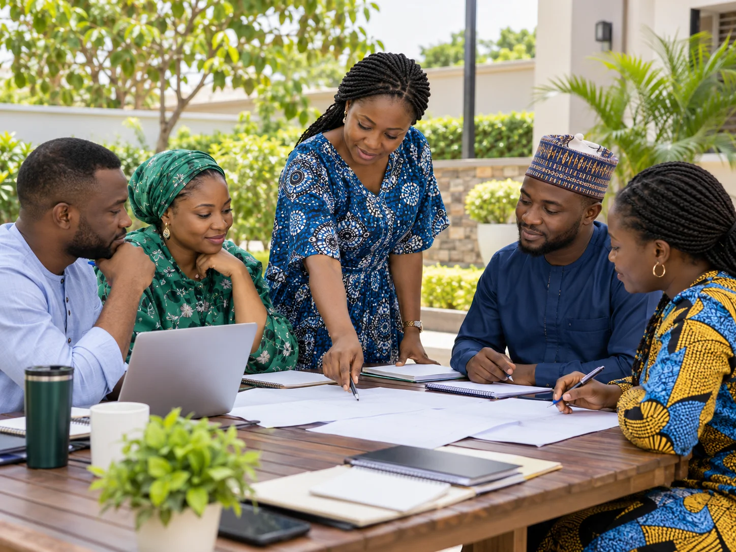 Illustrative Nigerian adults and facilitator discussing a community programme in a courtyard